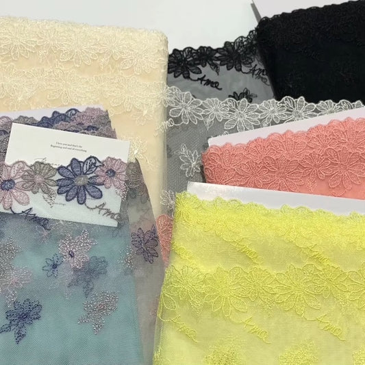 Encaje bordado amo, de malla doble cara, 18 cm de ancho con diseño floral en tonos pastel.