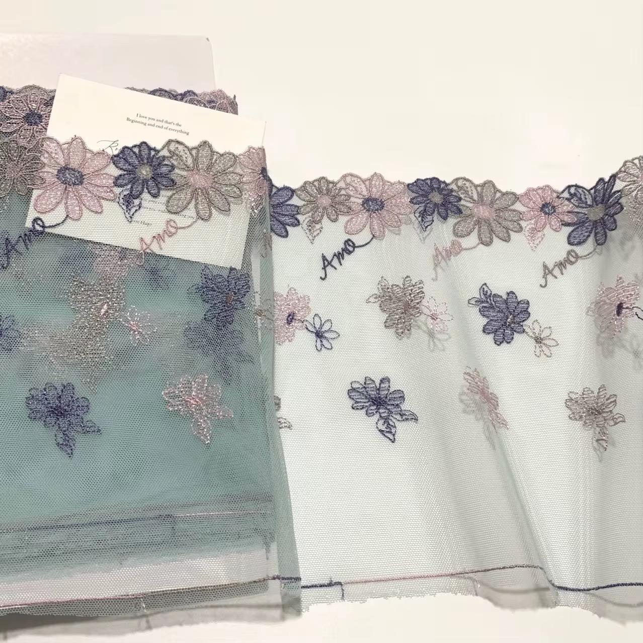 Encaje bordado amo, de malla doble cara, 18 cm de ancho con diseño floral en tonos pastel.