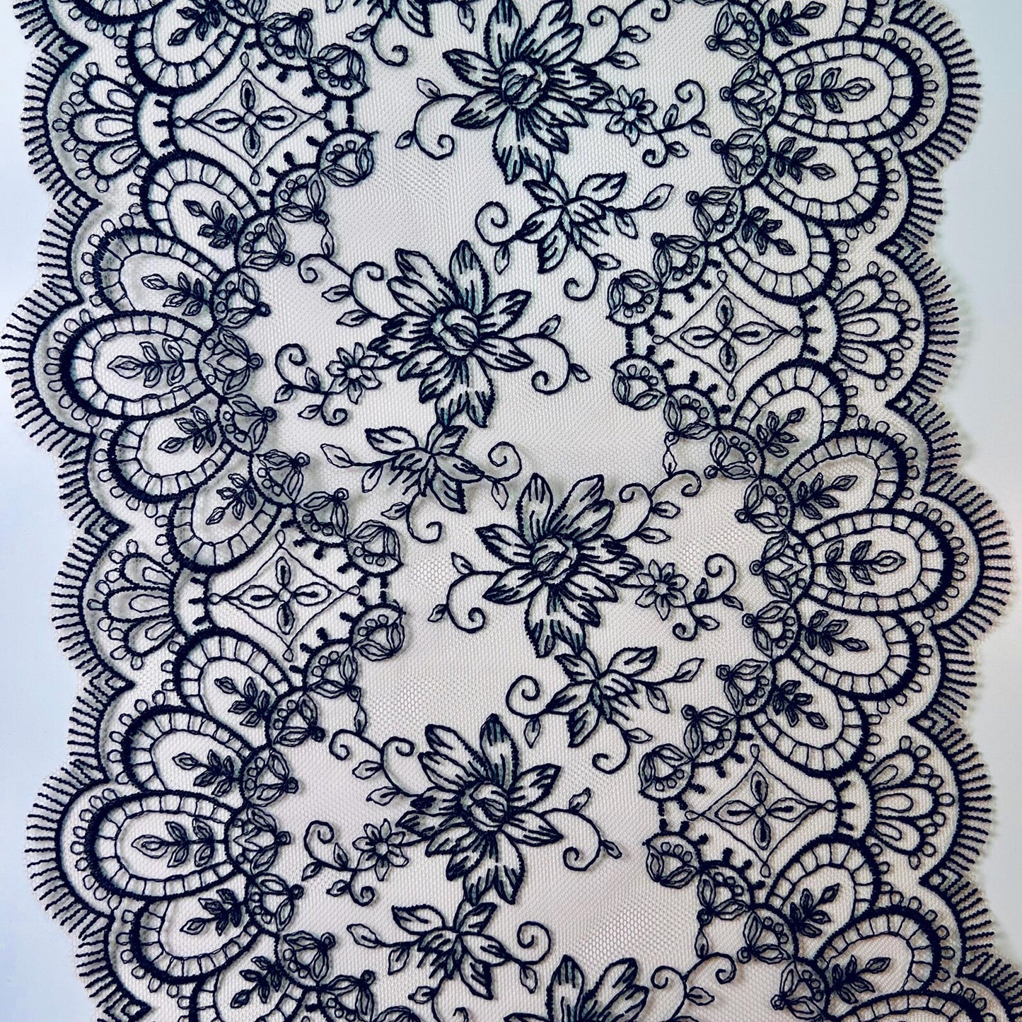 Encaje negro con bordado floral y bordes decorados para lencería elegante
