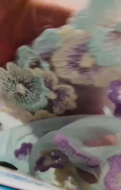 Vista completa de encaje bordado con flores coloridas
